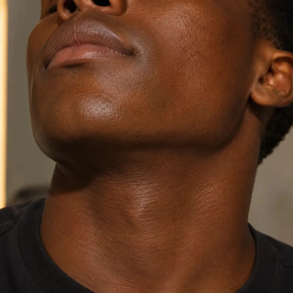 Close do queixo e pescoço com pele lisa em luz quente